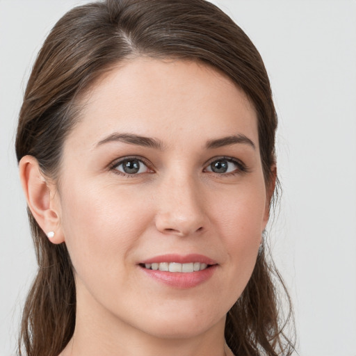 Joyful white young-adult female with long  brown hair and grey eyes