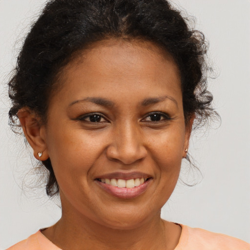 Joyful black adult female with medium  brown hair and brown eyes