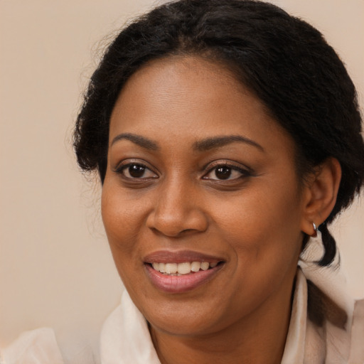 Joyful black adult female with medium  brown hair and brown eyes