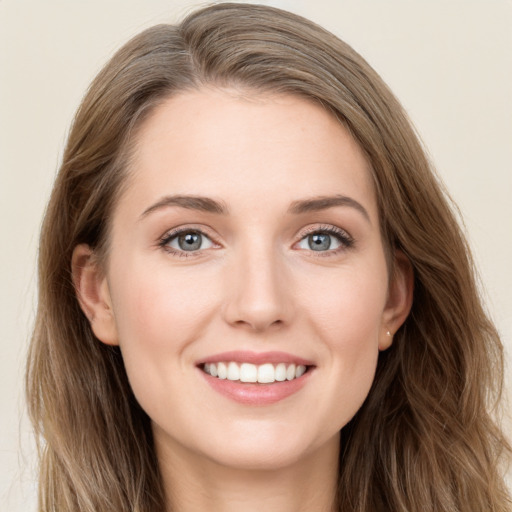 Joyful white young-adult female with long  brown hair and blue eyes