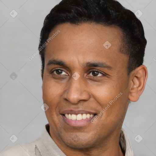 Joyful latino adult male with short  brown hair and brown eyes