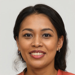 Joyful latino young-adult female with medium  brown hair and brown eyes