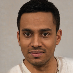 Joyful latino young-adult male with short  black hair and brown eyes