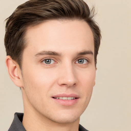 Joyful white young-adult male with short  brown hair and grey eyes