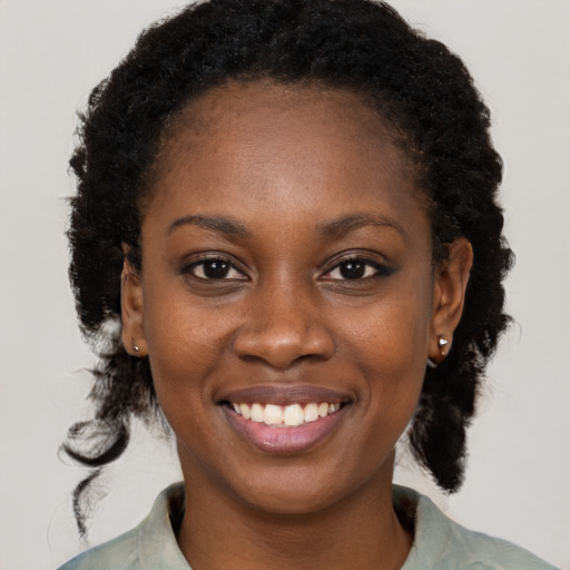 Joyful black young-adult female with medium  black hair and brown eyes