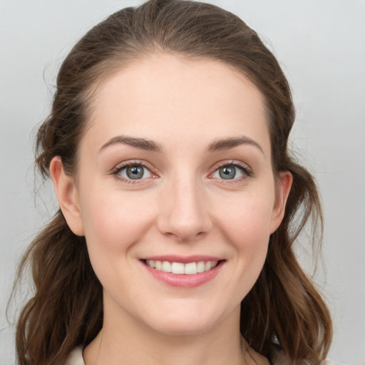 Joyful white young-adult female with medium  brown hair and grey eyes