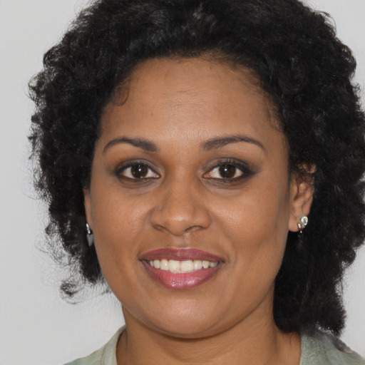 Joyful black adult female with medium  brown hair and brown eyes