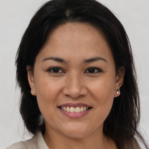 Joyful latino adult female with medium  brown hair and brown eyes