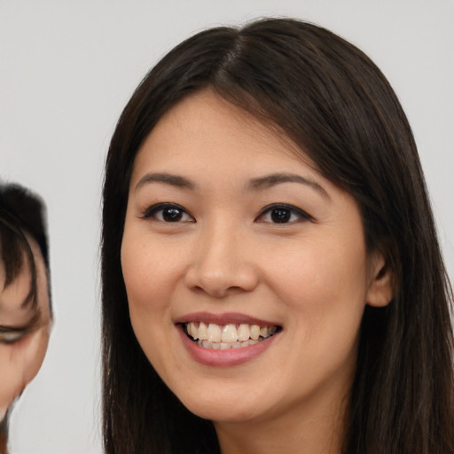 Joyful asian young-adult female with long  brown hair and brown eyes