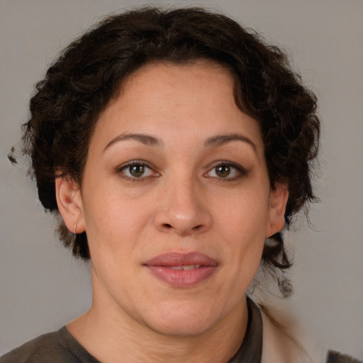 Joyful latino adult female with medium  brown hair and brown eyes