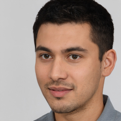 Joyful white young-adult male with short  black hair and brown eyes