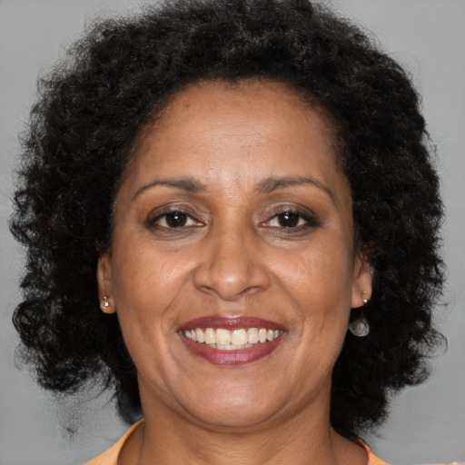 Joyful black adult female with long  brown hair and brown eyes