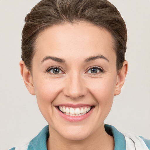 Joyful white young-adult female with short  brown hair and grey eyes