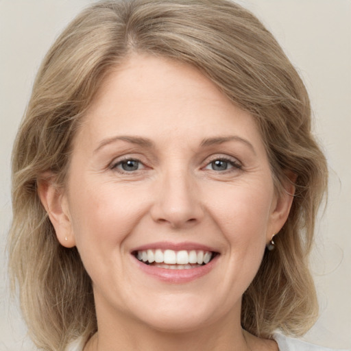 Joyful white adult female with medium  brown hair and grey eyes