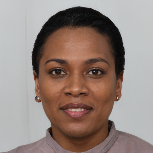 Joyful black young-adult female with short  black hair and brown eyes