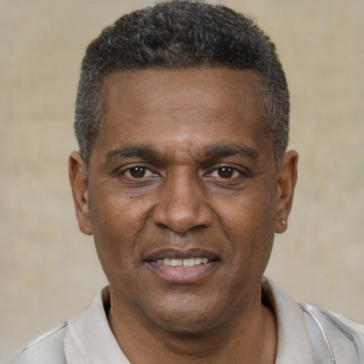 Joyful black adult male with short  black hair and brown eyes