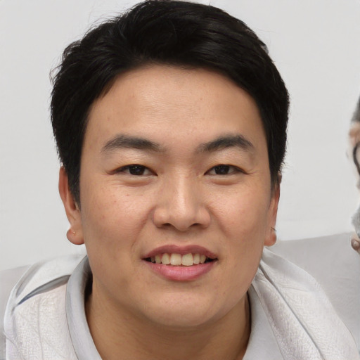 Joyful asian young-adult male with short  brown hair and brown eyes