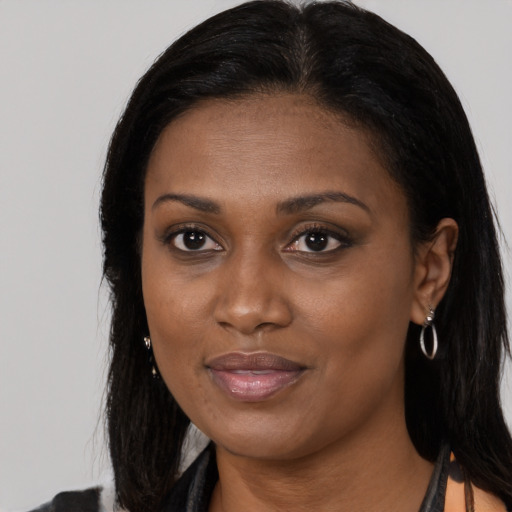 Joyful black young-adult female with long  brown hair and brown eyes