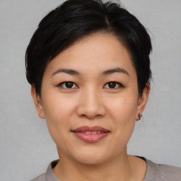 Joyful asian young-adult female with short  black hair and brown eyes