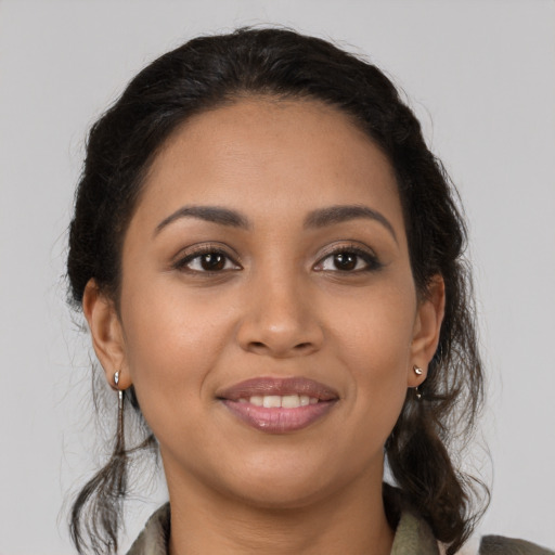 Joyful latino young-adult female with medium  brown hair and brown eyes