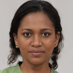 Joyful black young-adult female with medium  brown hair and brown eyes