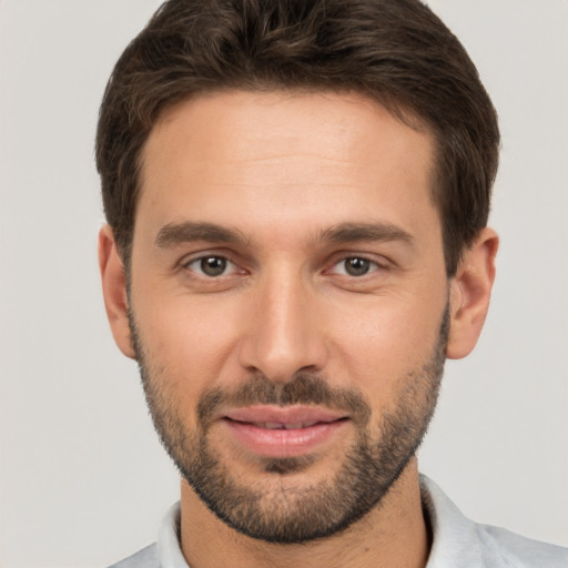 Joyful white young-adult male with short  brown hair and brown eyes