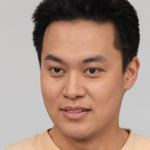 Joyful latino young-adult male with short  black hair and brown eyes