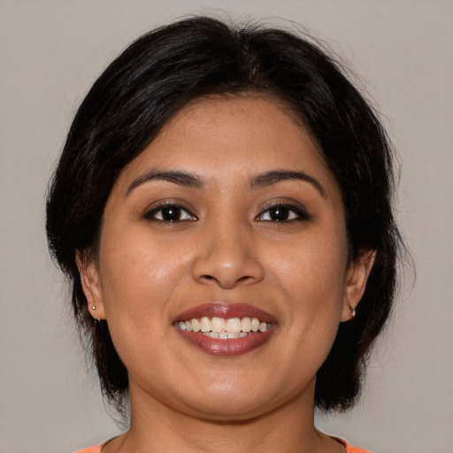 Joyful latino young-adult female with medium  brown hair and brown eyes