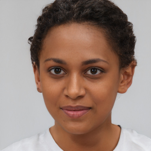 Joyful black young-adult female with short  brown hair and brown eyes