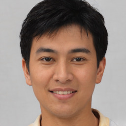 Joyful asian young-adult male with short  black hair and brown eyes