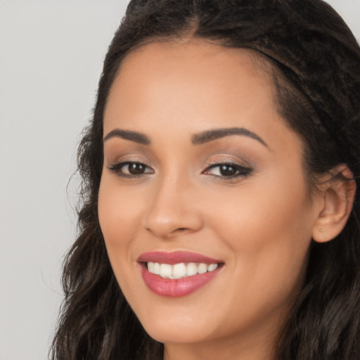 Joyful latino young-adult female with long  black hair and brown eyes