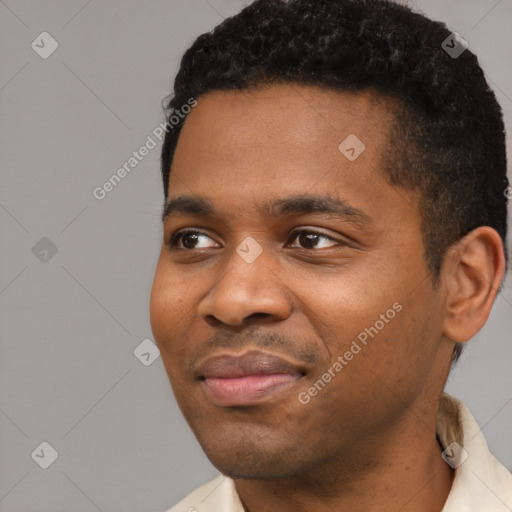 Joyful black young-adult male with short  black hair and brown eyes