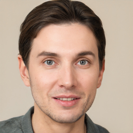 Joyful white young-adult male with short  brown hair and grey eyes