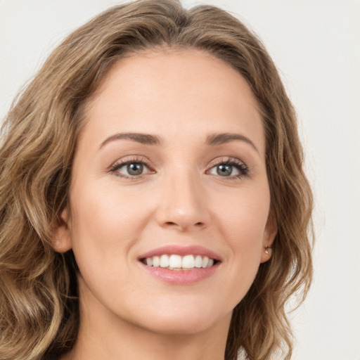 Joyful white young-adult female with long  brown hair and green eyes