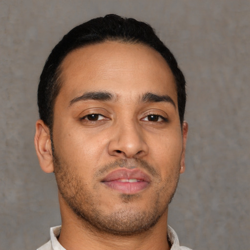 Joyful latino young-adult male with short  brown hair and brown eyes