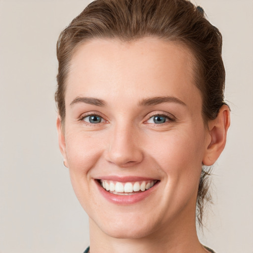 Joyful white young-adult female with short  brown hair and green eyes