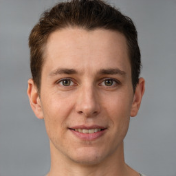 Joyful white young-adult male with short  brown hair and grey eyes