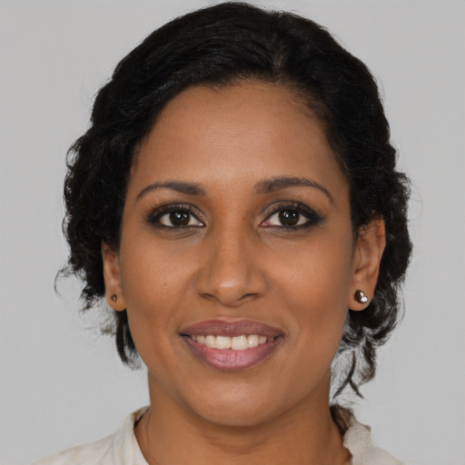 Joyful black young-adult female with medium  brown hair and brown eyes