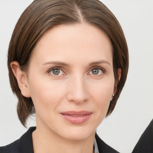 Joyful white young-adult female with medium  brown hair and grey eyes