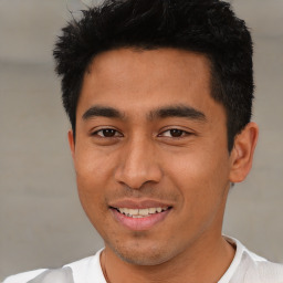 Joyful latino young-adult male with short  brown hair and brown eyes