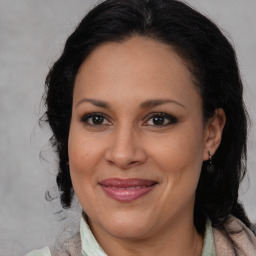 Joyful latino adult female with medium  brown hair and brown eyes