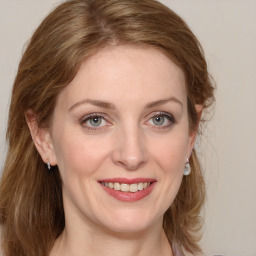 Joyful white young-adult female with medium  brown hair and blue eyes