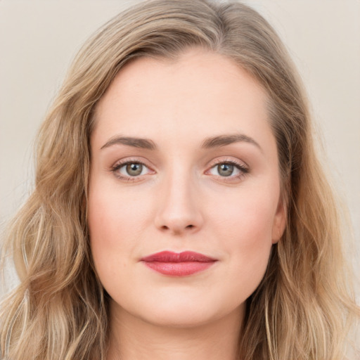 Joyful white young-adult female with long  brown hair and blue eyes