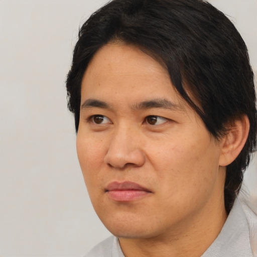 Joyful asian adult male with short  black hair and brown eyes