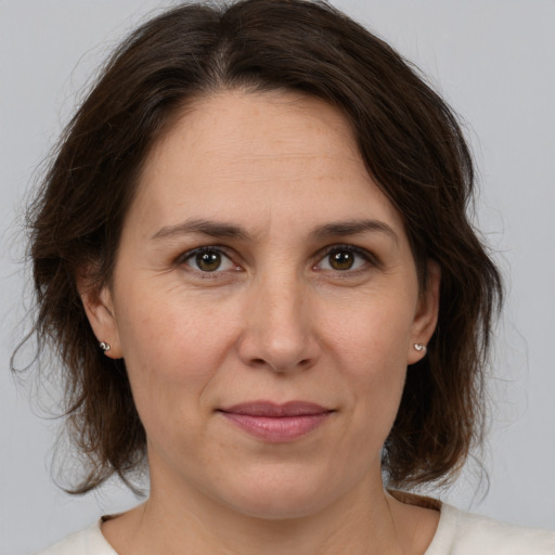 Joyful white adult female with medium  brown hair and brown eyes