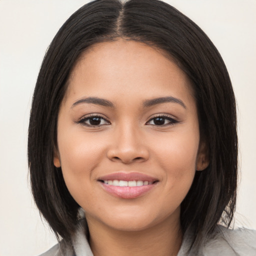 Joyful latino young-adult female with medium  brown hair and brown eyes