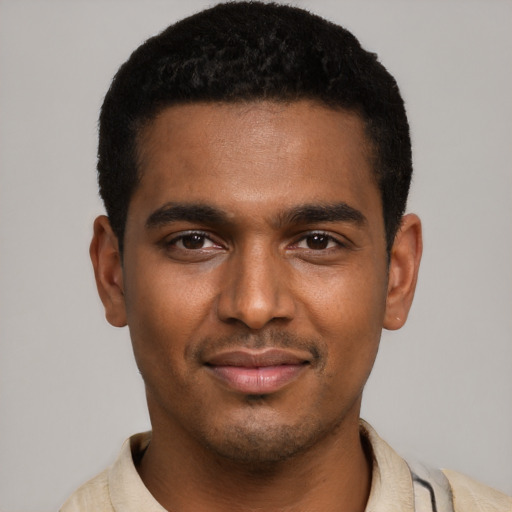 Joyful black young-adult male with short  black hair and brown eyes