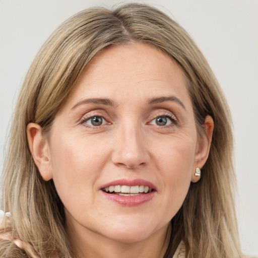 Joyful white adult female with long  brown hair and grey eyes