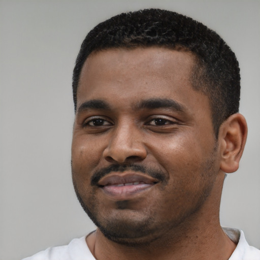 Joyful black young-adult male with short  black hair and brown eyes