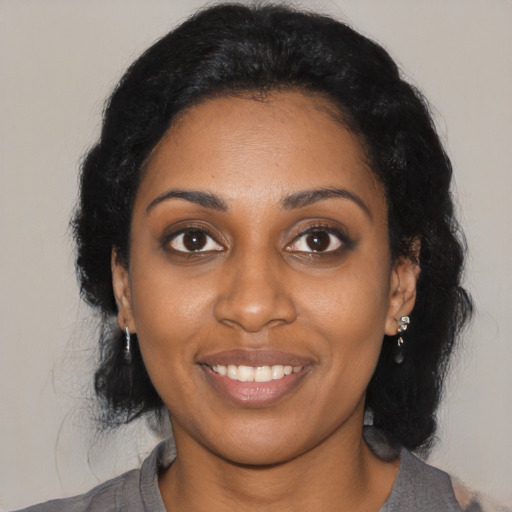 Joyful black young-adult female with medium  black hair and brown eyes